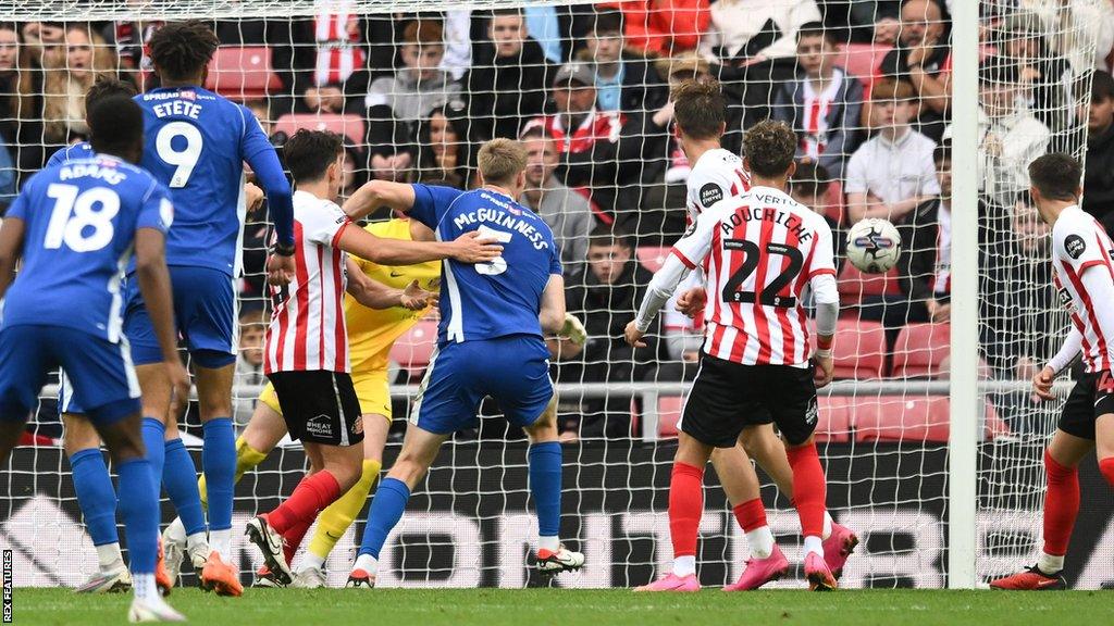 Mark McGuinness watches as his effort heads towards the net for Cardiff's winner