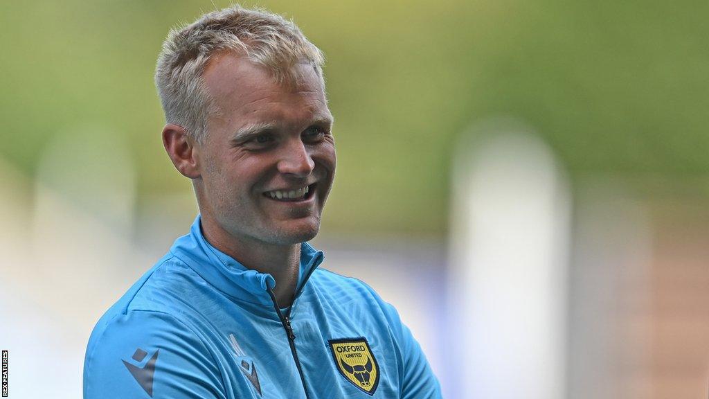 Oxford United boss Liam Manning smiling whilst talking to fans at an Oxford training session this summer.