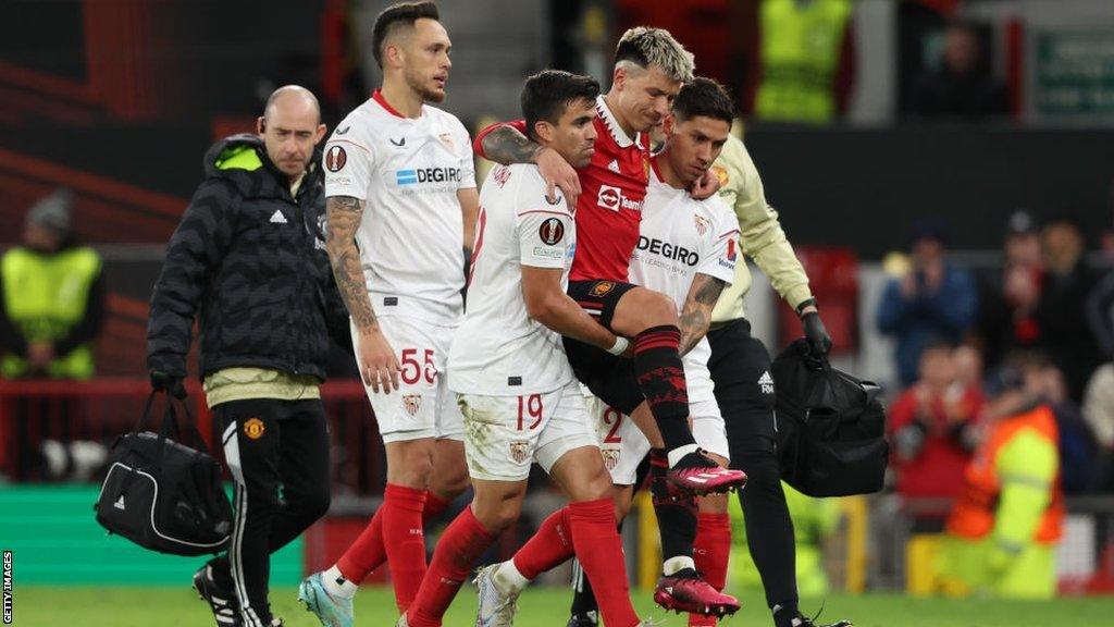 Lisandro Martinez is carried off the pitch against Sevilla