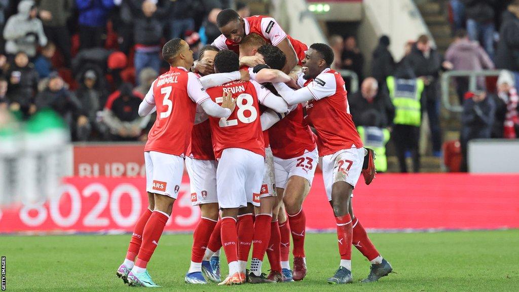 Rotherham United players huddled in celebration