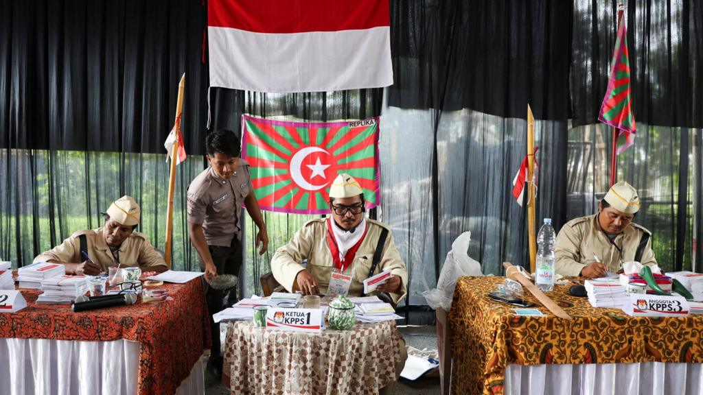 Electoral workers wear Defenders of the Homeland (PETA) costumes at a polling station during the general election in South Tangerang,