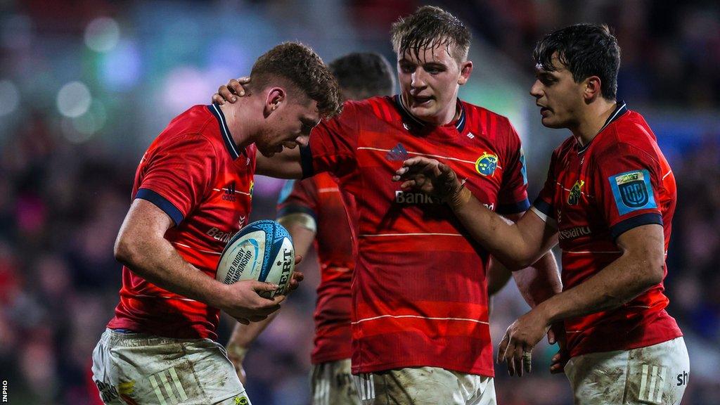 Ben Healy celebrates after scoring a try against Ulster with Munster team-mates Gavin Coombes and Antoine Frisch