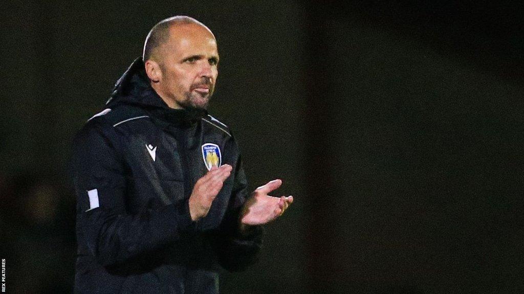 Colchester United interim manager Matthew Etherington applauds his players during their game with Grimsby