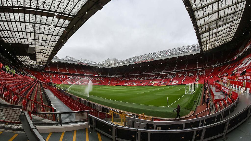 An image of inside an empty Old Trafford looking towards the Stretford End from the opposite corner