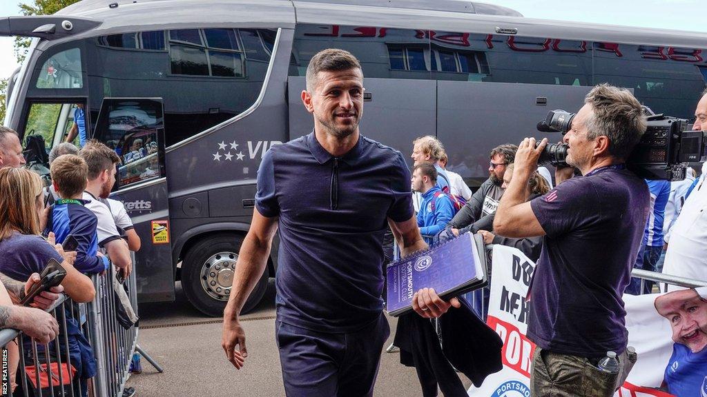 Portsmouth head coach John Mousinho arrives off the team bus for a League One match.