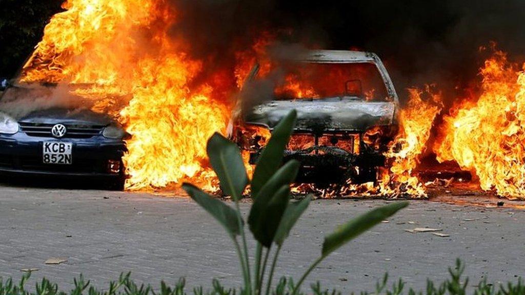 Cars are seen on fire at the scene of explosions and gunshots in Nairobi, Kenya January 15, 2019