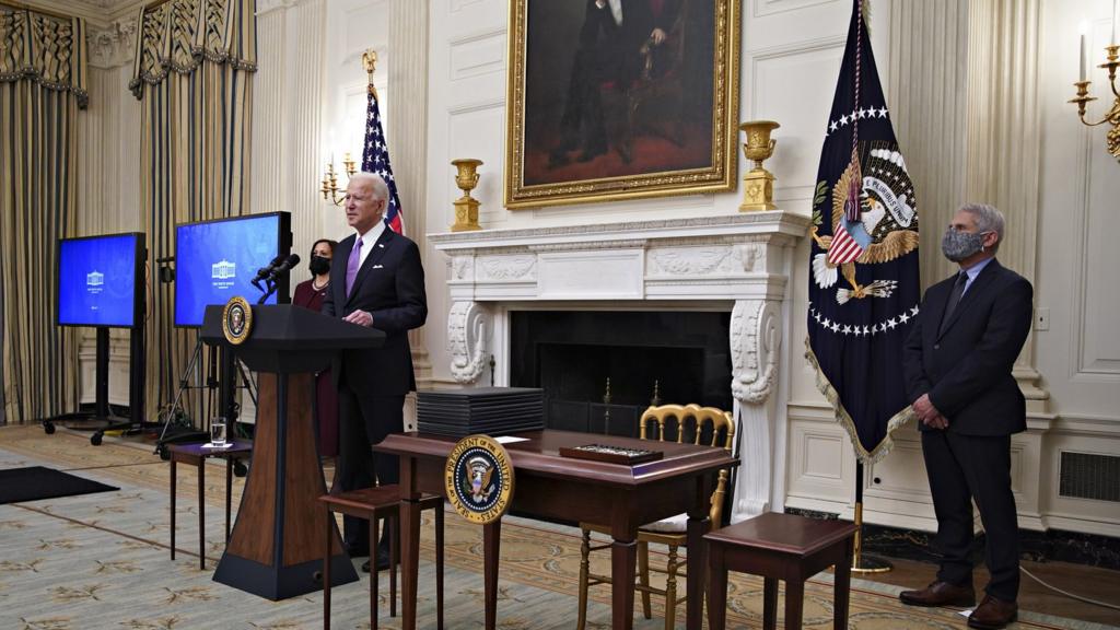 President Joe Biden speaks as US Vice President Kamala Harris, left, and Anthony Fauci, director of the National Institute of Allergy and Infectious Diseases, right, listen during an event on his administration's Covid-19 response in the State Dining Room of the White House in Washington, DC, USA, on 21 January 2021