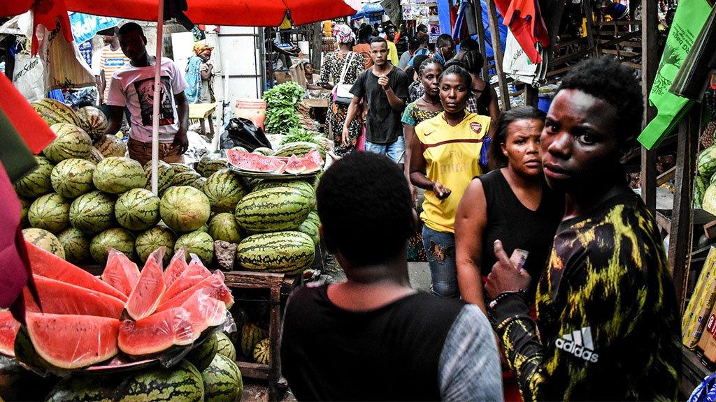 People walk at a market without social distancing April 15, 2020.