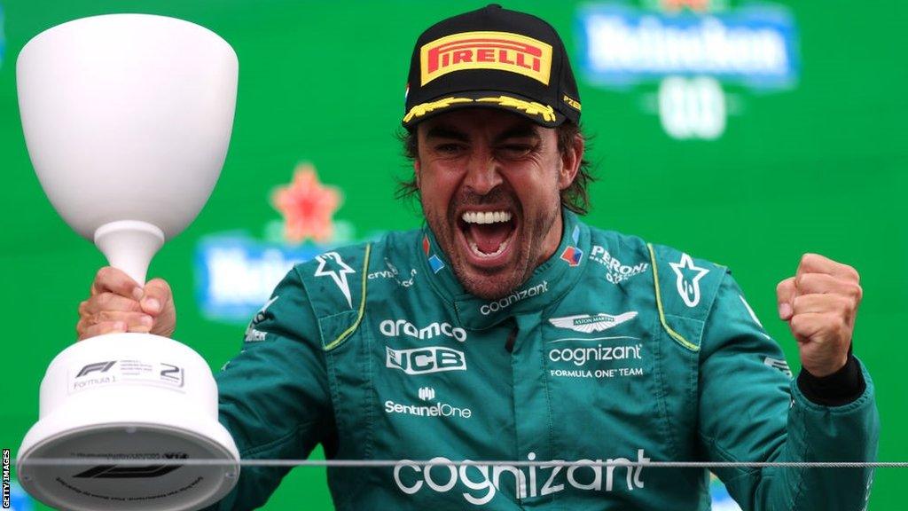 Fernando Alonso cheers with delight holding his giant runners-up trophy at Zandvoort