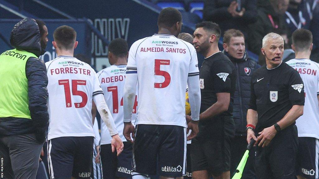 Referee Sunny Singh Gill leads the players off the pitch