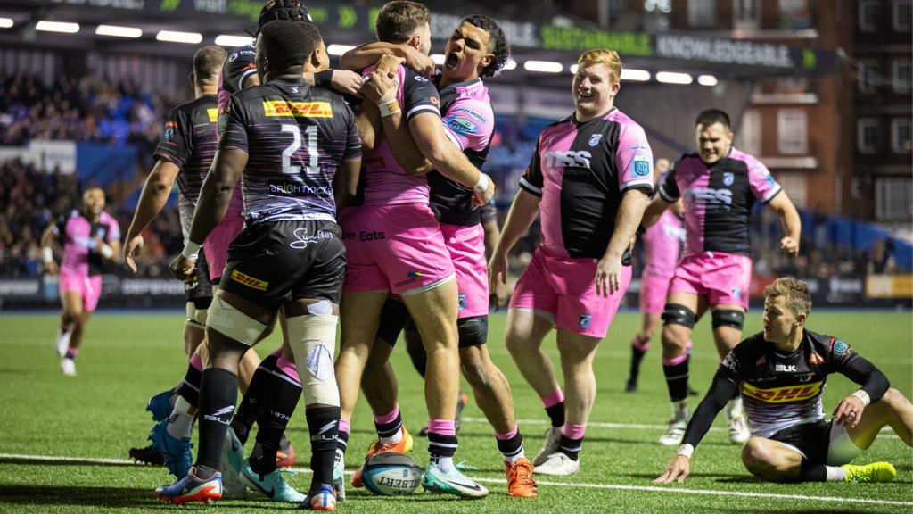 Herschel Jantjies (21) walks away as Cardiff's Mason Grady (obscured) celebrates with McKenzie Martin as Rhys Carre (R) smiles with delight