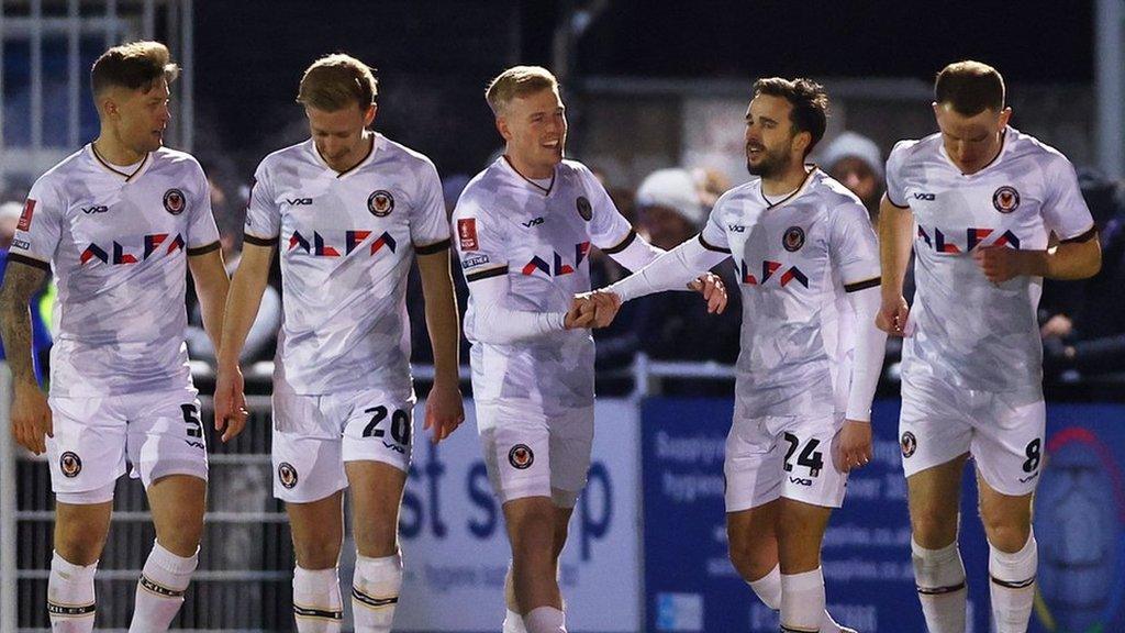 Four Newport players celebrate their side's goal against Eastleigh with high fives