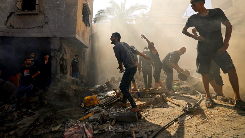 Palestinians react as they check the rubble of a building, in Khan Yunis on November 6, 2023, amid the ongoing battles between Israel and the Palestinian group Hamas