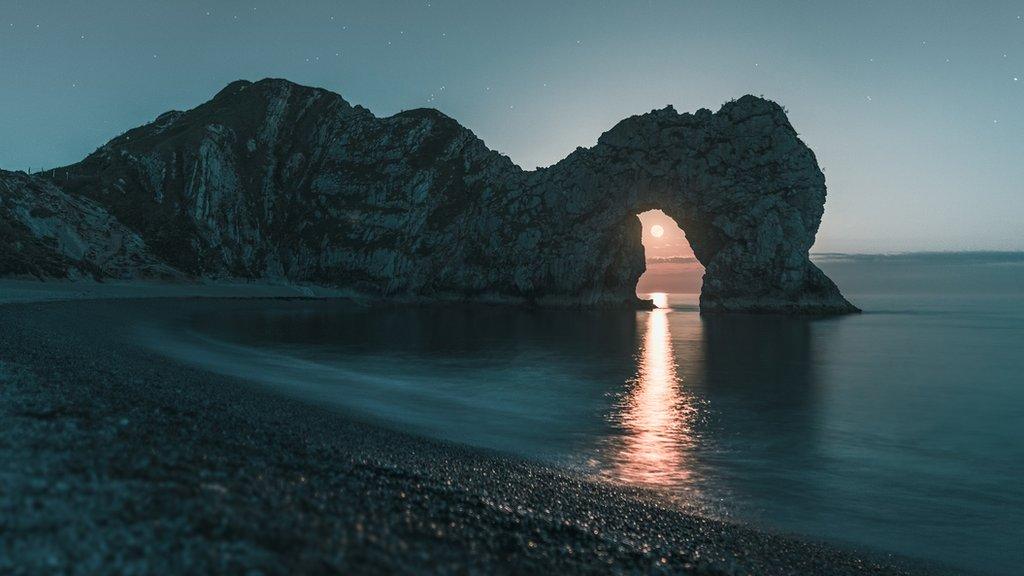 The moon through Durdle Door