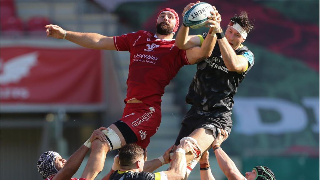 Blade Thomson of Scarlets and Thomas Ahern of Munster compete for the ball