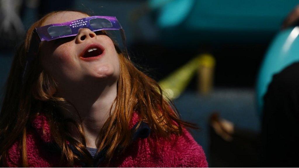 child looking at eclipse