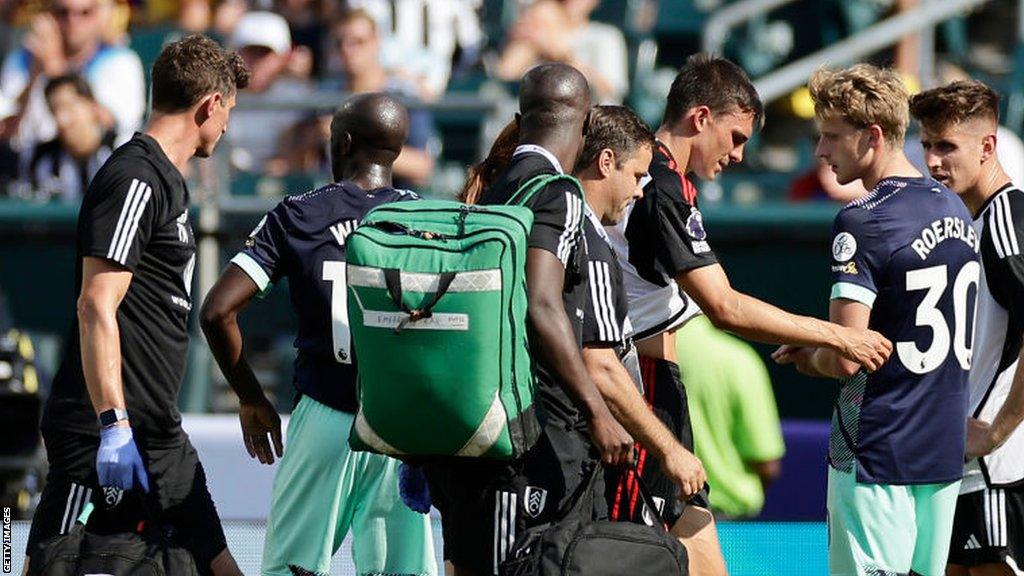 Fulham midfielder Joao Palhinha is led from the field