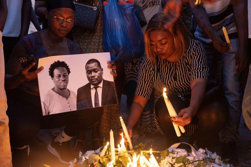 An image is held of Paulo Guambe (L) and adviser and lawyer Elvino Dias (R) who worked with presidential candidate Venâncio Mondlane at a candle-lit vigil 