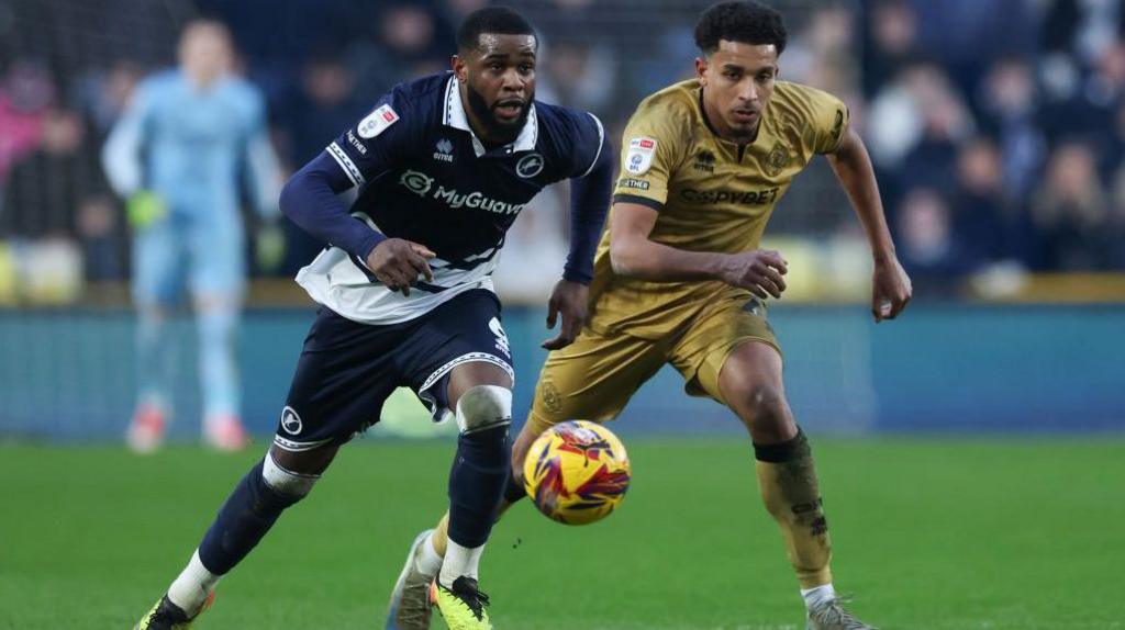 Millwall's Japhet Tanganga [left] and QPR's Alfie Lloyd [right] duel for the ball