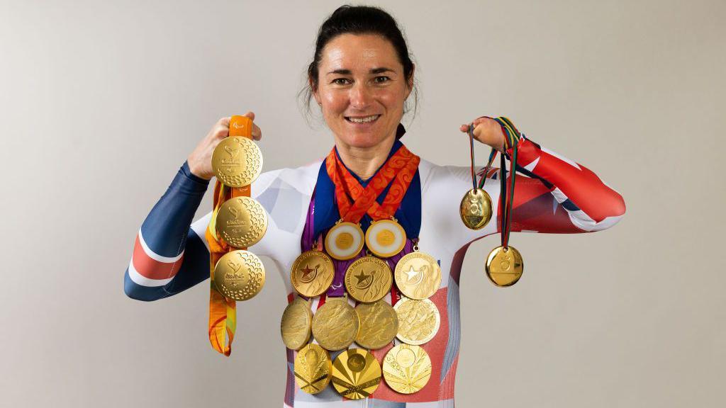 Dame Sarah Storey posing with her gold medals