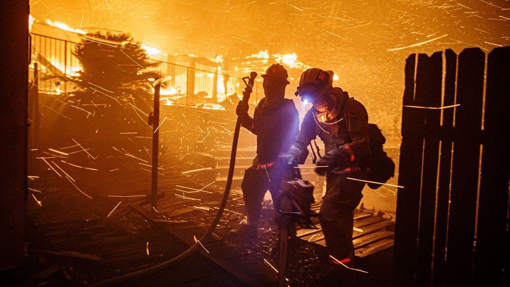 Firefighters work to control the flames in the North Park neighbourhood if San Bernardino, California