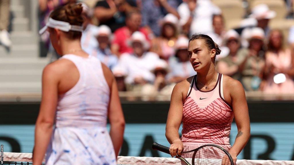 Ukraine's Elina Svitolina walks past Belarus' Aryna Sabalenka as she waits at the French Open net