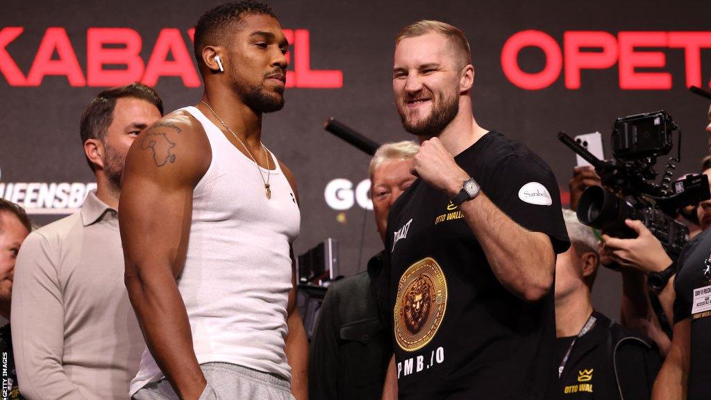 Anthony Joshua with his hands in his pockets stares at Otto Wallin