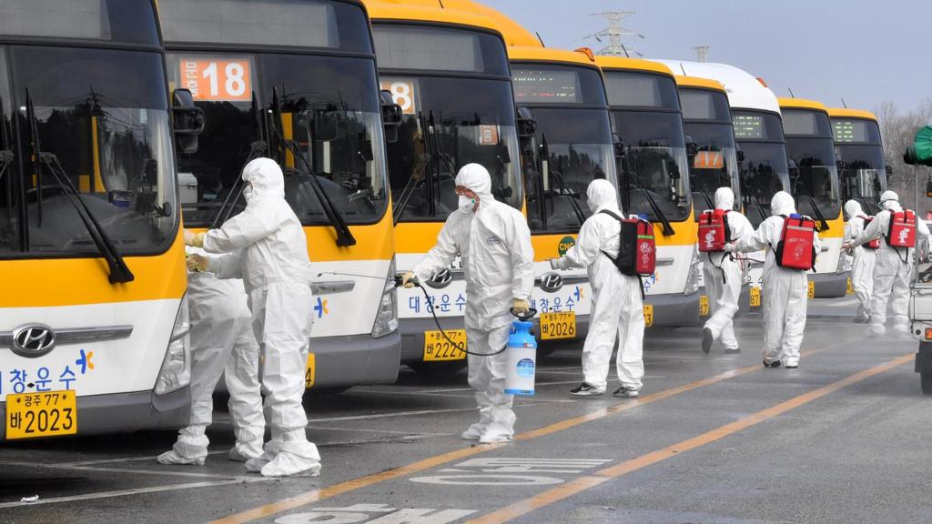 South Korean workers disinfect buses