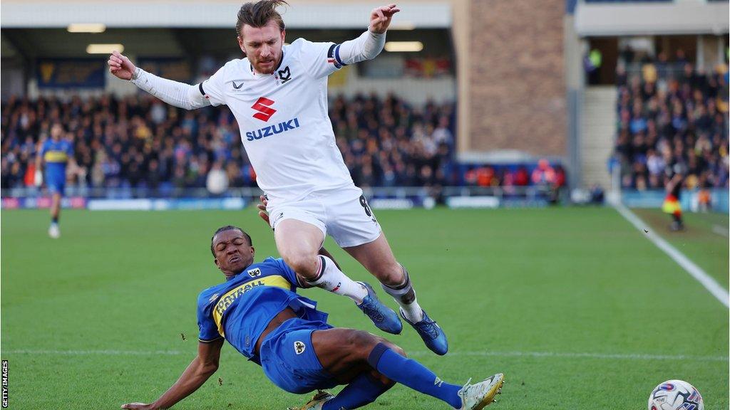 Alex Gilbey of MK Dons was among 12 players booked in the game against AFC Wimbledon