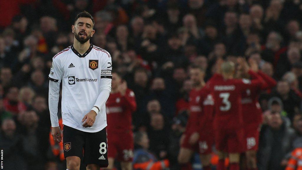 Bruno Fernandes reacting with Liverpool players celebrating a goal in the background