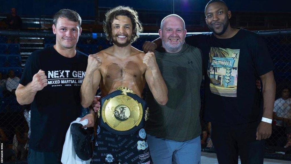 Rock celebrates a victory with his coaches and team-mates.