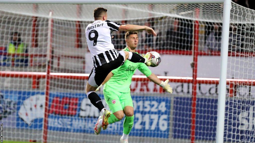 Notts County striker Macaulay Langstaff tries to divert the ball past Morecambe keeper Stuart Moore