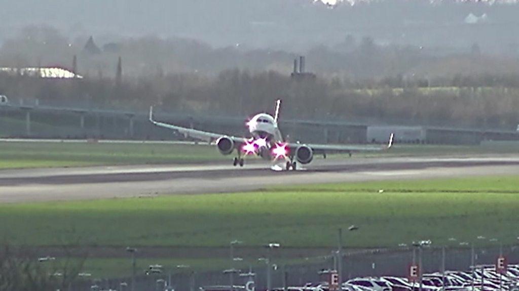 A British Airways plane struggles to land at Heathrow Airport as it approaches the runway.