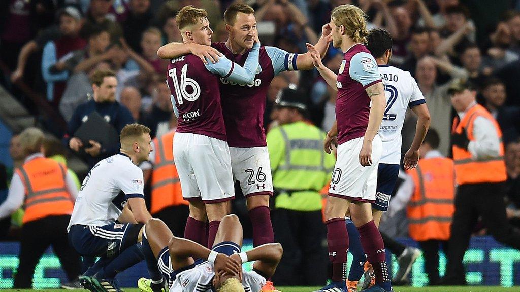 Aston Villa players John Terry, James Bree and Birkir Bjarnasson celebrate as Middlesbrough winger Adam Traore lies on the pitch