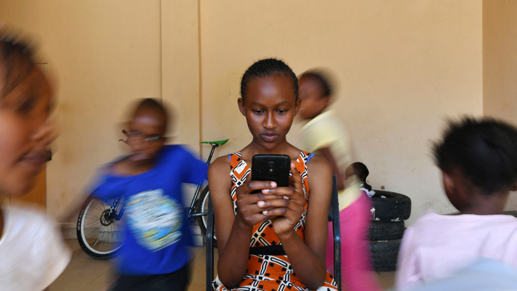 A girl on a phone in a flat in Nairobi, Kenya