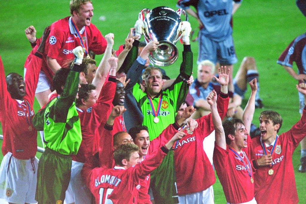 Manchester united holding the Champions League trophy