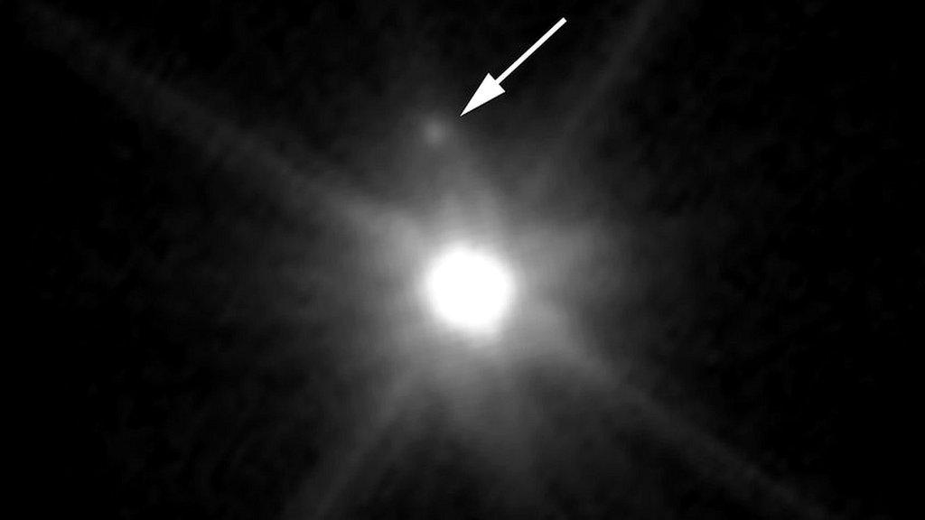 A picture showing the dwarf planet Makemake and it's newly discovered moon.