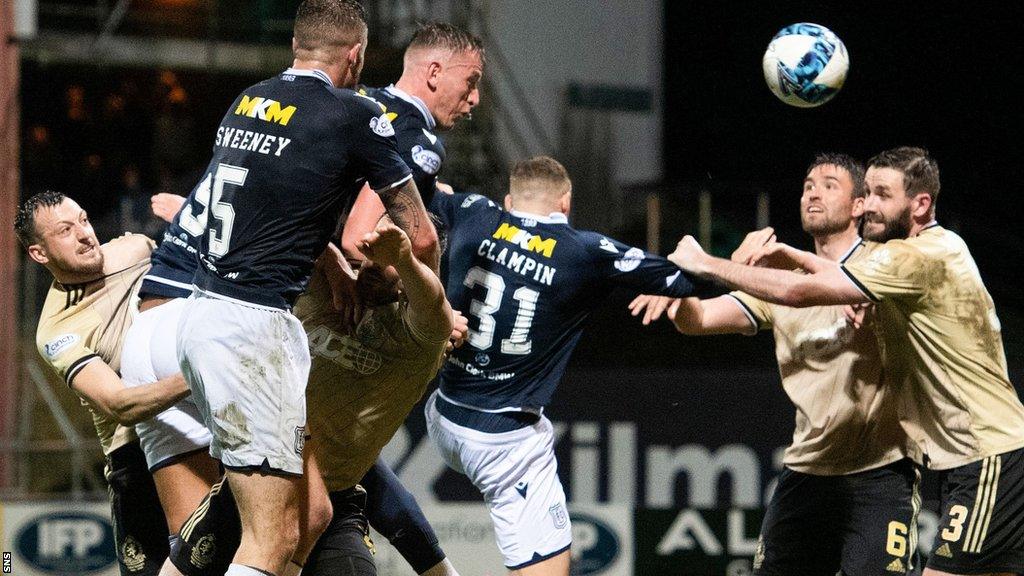 Dundee's Lee Ashcroft (centre) heads for goal