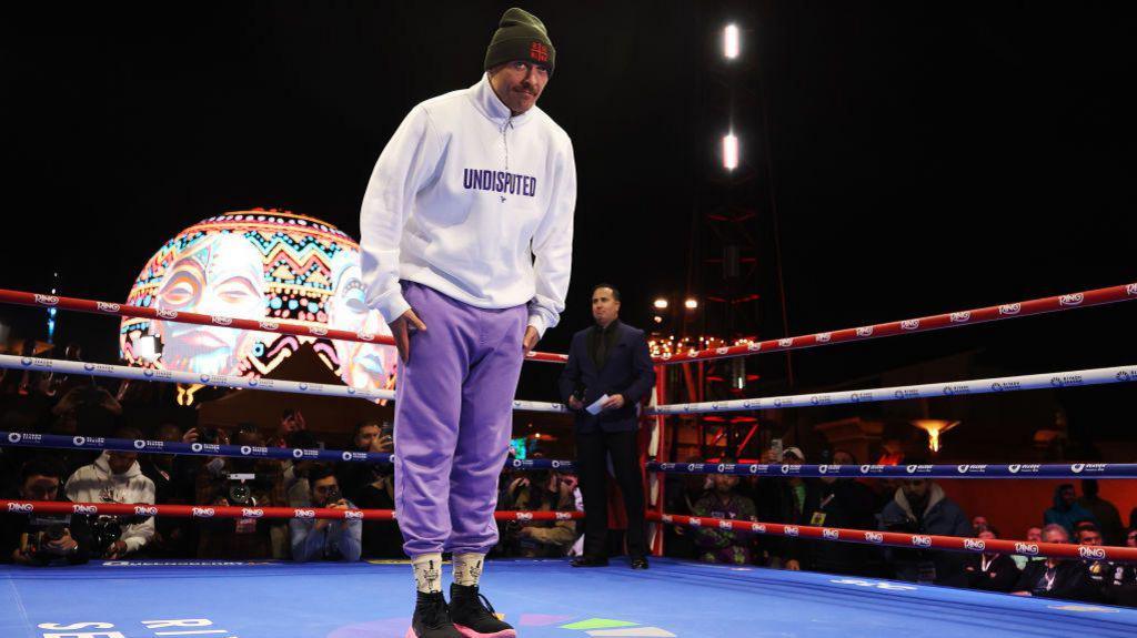 Oleksandr Usyk in a white hoodie that says 'undisputed' on it