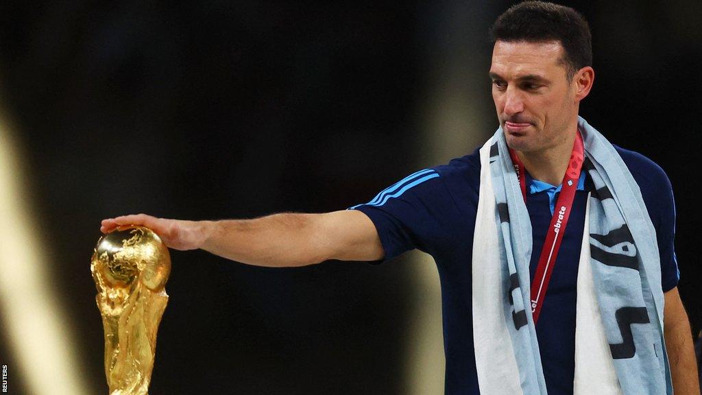 Argentina manager Lionel Scaloni touches the World Cup trophy following his team winning last year's tournament