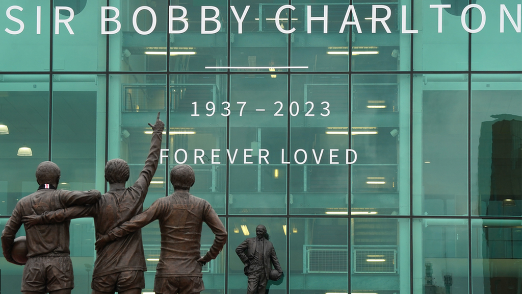 A tribute in memory of Sir Bobby Charlton is displayed on the outside of the main entrance at Old Trafford