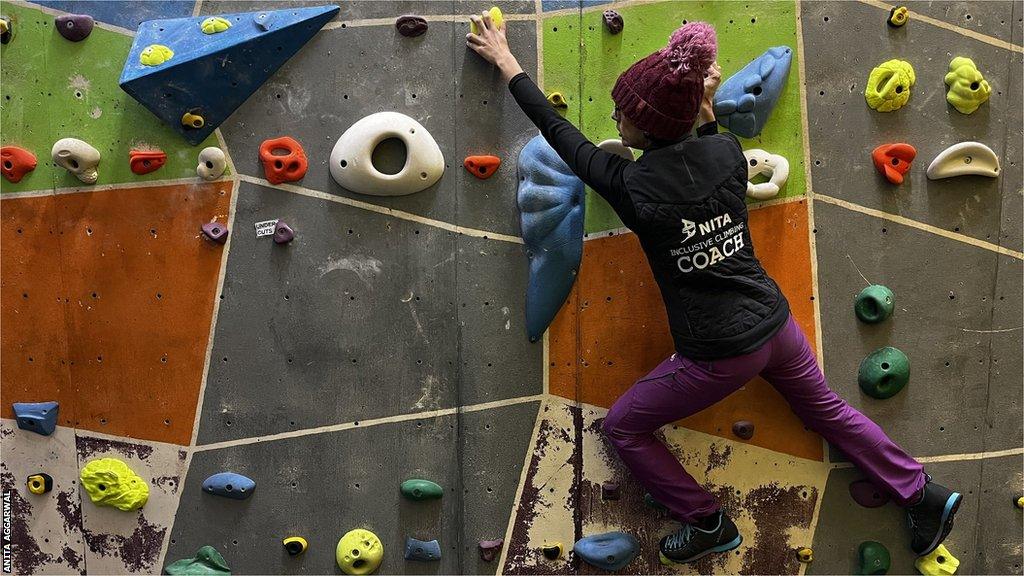 Anita Aggarwal moving across a climbing wall