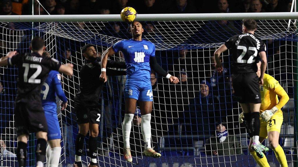 Emanuel Aiwu heads the ball in front of goal