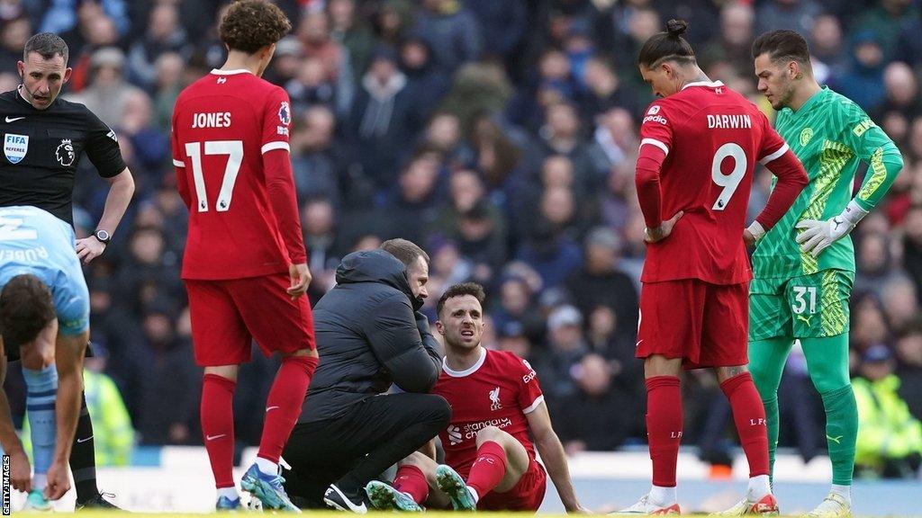 Liverpool forward Diogo Jota receives treatment during a match against Manchester City