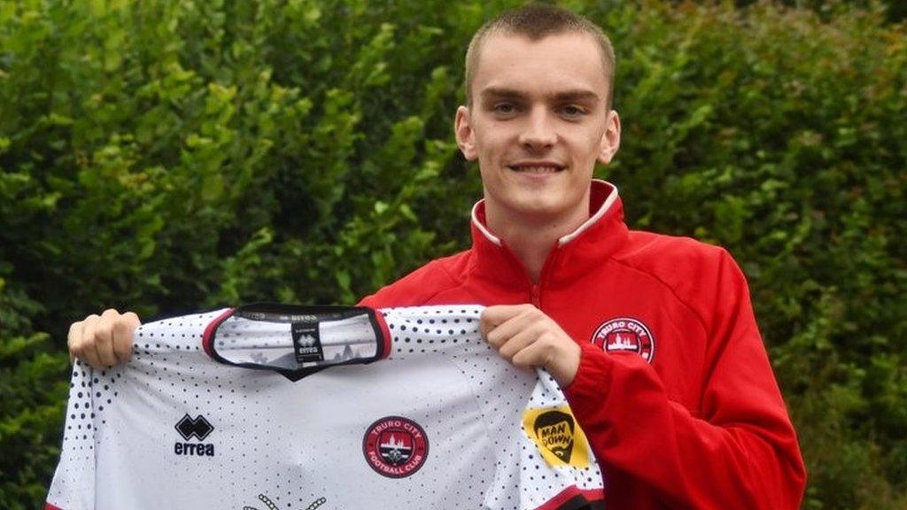 Adam Porter holds up a Truro City shirt