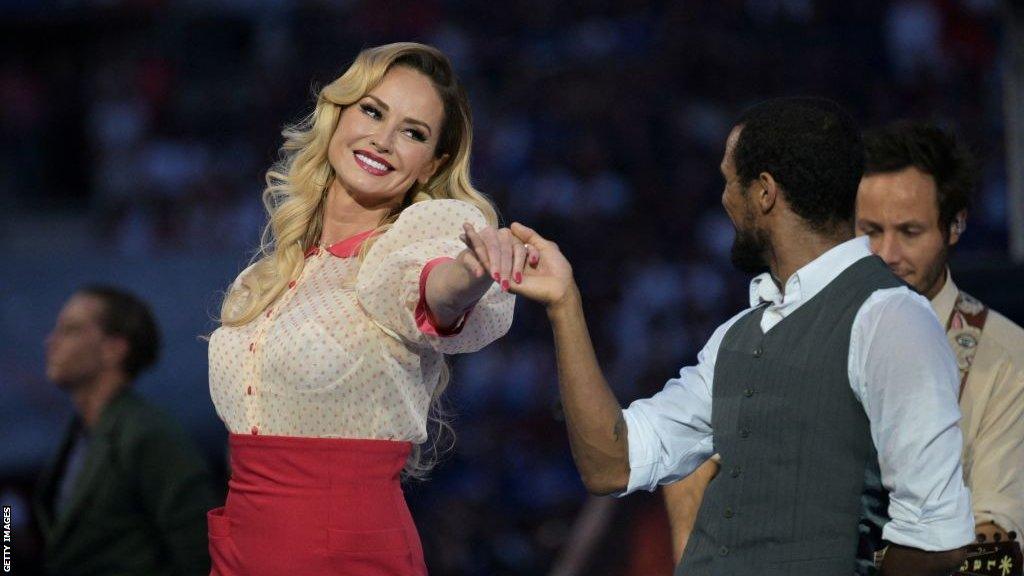 Adriana Karembeu dances while smiling