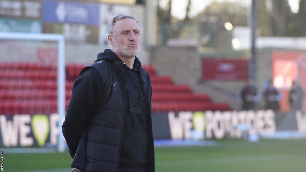 Port Vale boss Andy Crosby watches on during warm-up