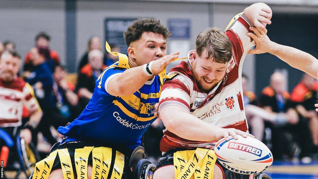 Tom Halliwell of Leeds Rhinos tries to tackle Wigan Warriors' Declan Roberts