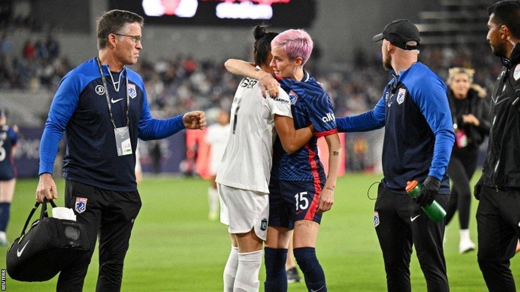 Injured OL Reign forward Megan Rapinoe hugs NJ/NY Gotham FC defender Ali Krieger as she leaves the 2023 NWSL final