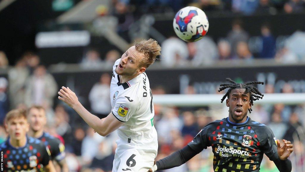 Swansea's Harry Darling stretches to head towards goal